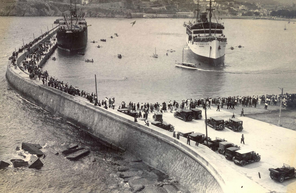 El port de Sant Feliu ple de gent esperant l’arribada d’un vaixell de passatgers (1925 – 1935). AMSFG. Fons Espuña – Ibañez. Autor: Desconegut.